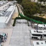 Amplio camper park en Alicante con numerosas autocaravanas y caravanas aparcadas, algunas con paneles solares.
