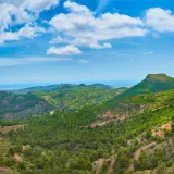 Paisaje montañoso verde con el mar al fondo. Ideal para camping en la Sierra Calderona.