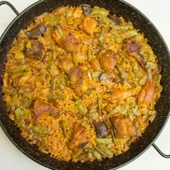 Paella mixta recién hecha, con pollo, judías verdes y arroz dorado. Un delicioso paella rezept para compartir.