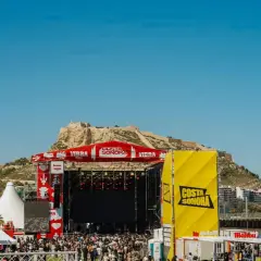 Gran concierto en la costa Sonora, con un escenario imponente y una multitud disfrutando bajo el sol.