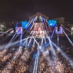 Multitud vibrante en el Zevra Festival, disfrutando de un espectáculo de luces deslumbrante y la energía de la noche.