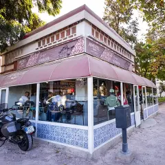 La pergola Valencia, un café con terraza y moto aparcada, invita a disfrutar del día.