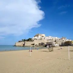 Playa de Peñíscola, con su imponente castillo y casitas blancas, se alza sobre el mar Mediterráneo. Un día soleado en el grao de Castellón.