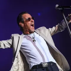 Marc Anthony canta con pasión en su concierto de Valencia, con los brazos extendidos y la boca abierta.