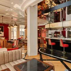 Elegante bar con taburetes rojos y barra de mármol. Un lugar ideal para estimar valencia y disfrutar de la noche.