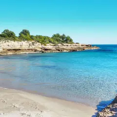 La cala vidre, con su arena dorada y aguas cristalinas, invita a un baño refrescante bajo el sol.