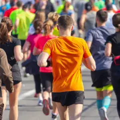 Corredores en la carrera 30k Sagunto, con un hombre de naranja en primer plano.