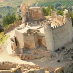 El imponente castillo de Xivert se alza sobre una colina, rodeado de vegetación y campos cultivados. Sus ruinas cuentan historias de batallas y tiempos pasados.