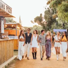 Un grupo de amigos pasea por un festival culinario en Valencia, disfrutando del ambiente veraniego y la buena compañía.