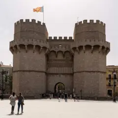 Torres de Serranos, un portal gótico que evoca la historia de Valencia. Turistas pasean ante esta imponente estructura.