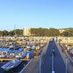 El puerto deportivo Las Fuentes, con sus barcos amarrados y el mar azul, se extiende bajo un cielo despejado.