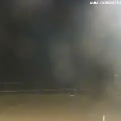 La webcam Patacona muestra una playa nocturna con palmeras y el mar. La imagen está algo borrosa.