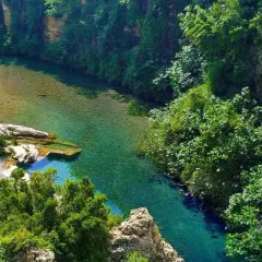 El lago de Anna, un oasis de aguas cristalinas rodeado de exuberante vegetación y rocas.