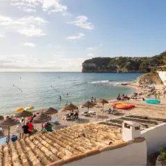 La cala Barraca, con su playa de guijarros, aguas cristalinas y acantilados, es un paraíso para disfrutar del sol y el mar. Kayaks y sombrillas invitan al descanso.