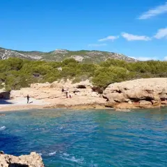 La cala mundina, con sus aguas turquesas y rocas doradas, invita a disfrutar de un día soleado. Un rincón idílico para desconectar.