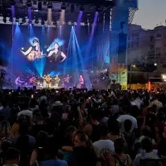 Multitud disfrutando del maror fest, con un gran escenario iluminado y artistas tocando.