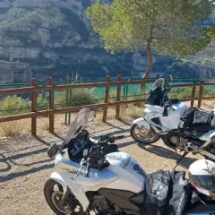 Dos motos blancas listas para explorar las **rutas en moto Comunidad Valenciana**, con un paisaje de cañón y embalse al fondo.