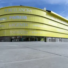 El **estadio La Cerámica** de color amarillo brillante, con el nombre del club Villarreal CF visible.