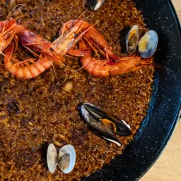Paella de marisco con gambas rojas, mejillones y almejas, lista para disfrutar.
