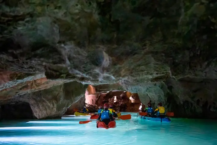 Kayakistas exploran las impresionantes cuevas de San José, navegando por aguas turquesas bajo formaciones rocosas milenarias.
