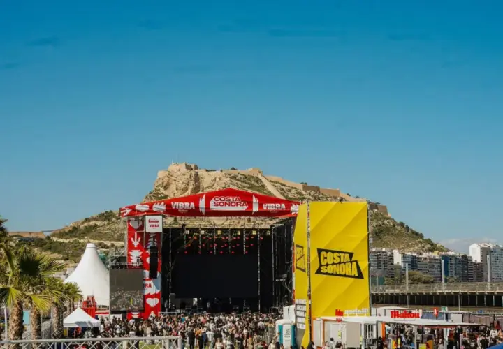 Gran concierto en la costa Sonora, con un escenario imponente y una multitud disfrutando bajo el sol.