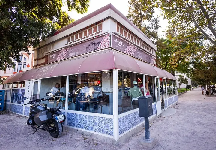 La pergola Valencia, un café con terraza y moto aparcada, invita a disfrutar del día.