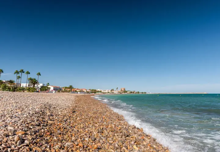 La playa Gurugú de Benicarló, con su guijarro y palmeras, invita a un día soleado junto al mar Mediterráneo.