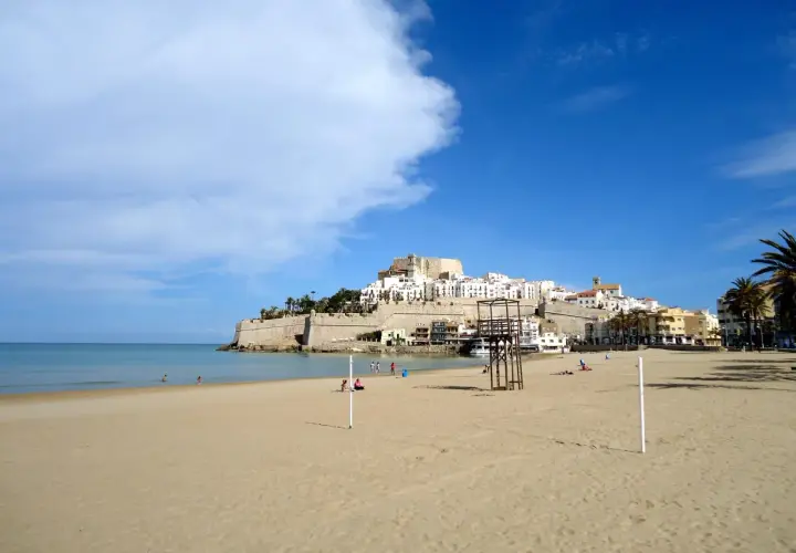 Playa de Peñíscola, con su imponente castillo y casitas blancas, se alza sobre el mar Mediterráneo. Un día soleado en el grao de Castellón.
