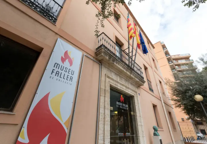 Fachada del Museu Faller de València con un cartel anunciador y banderas ondeando.