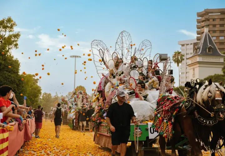 La batalla de las flores Valencia en pleno apogeo. Carrozas adornadas, gente lanzando flores y un ambiente festivo.