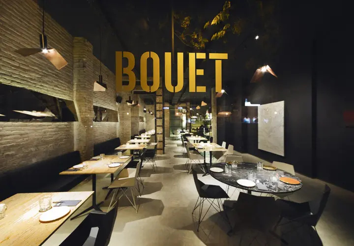 El interior moderno de **el bouet valencia**, con mesas listas para cenar y un ambiente elegante.