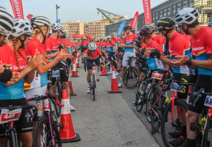 Ciclistas compiten en un gran fondo en Valencia. El público anima a los participantes mientras uno cruza la meta.