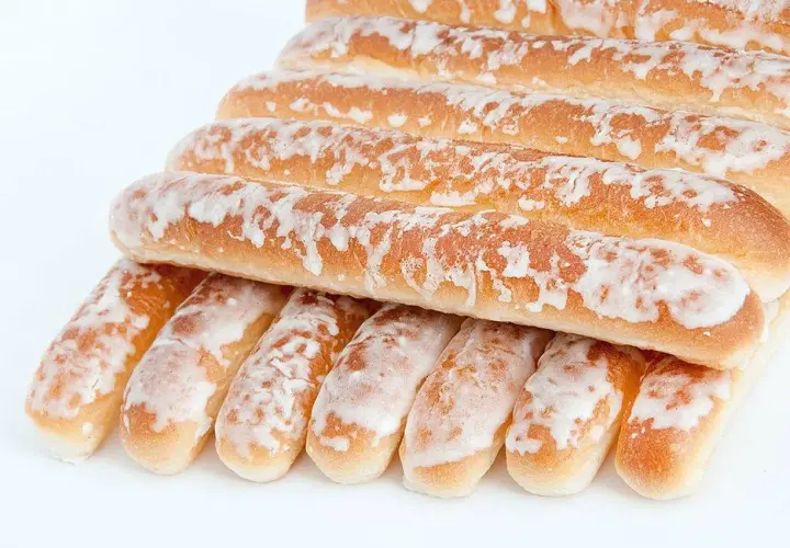 Dulces típicos de Valencia: barritas doradas cubiertas de glaseado blanco, apiladas en una pirámide.