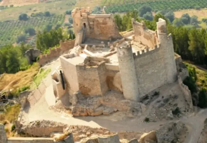 El imponente castillo de Xivert se alza sobre una colina, rodeado de vegetación y campos cultivados. Sus ruinas cuentan historias de batallas y tiempos pasados.
