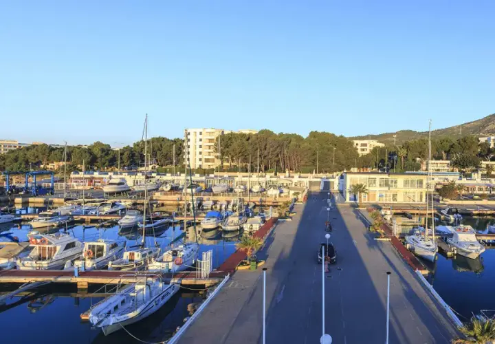 El puerto deportivo Las Fuentes, con sus barcos amarrados y el mar azul, se extiende bajo un cielo despejado.