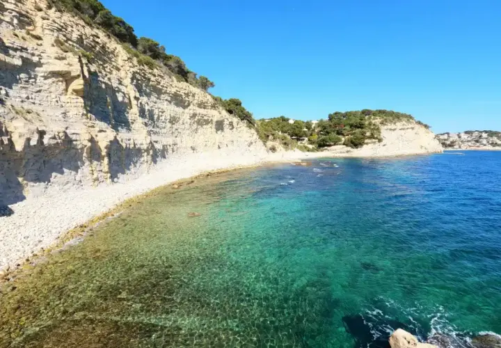 Aguas cristalinas y acantilados en la cala llobella, un paraíso mediterráneo.