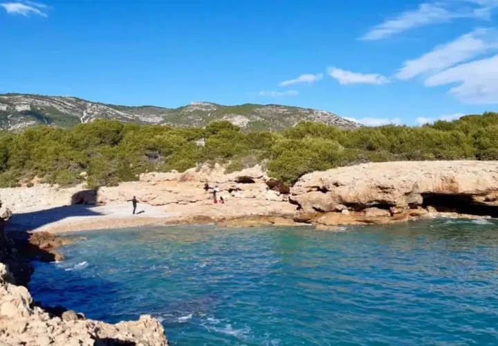 La cala mundina, con sus aguas turquesas y rocas doradas, invita a disfrutar de un día soleado. Un rincón idílico para desconectar.