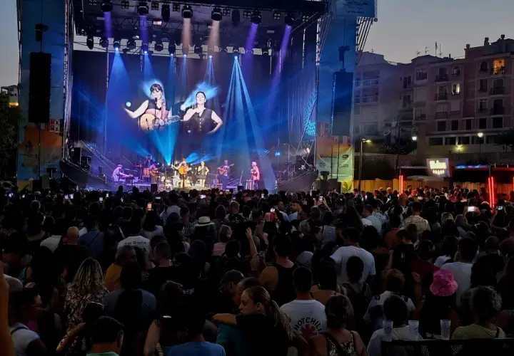 Multitud disfrutando del maror fest, con un gran escenario iluminado y artistas tocando.