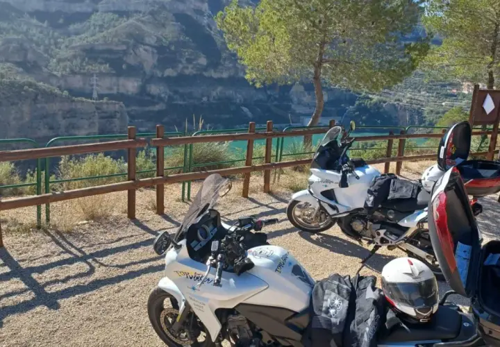 Dos motos blancas listas para explorar las **rutas en moto Comunidad Valenciana**, con un paisaje de cañón y embalse al fondo.