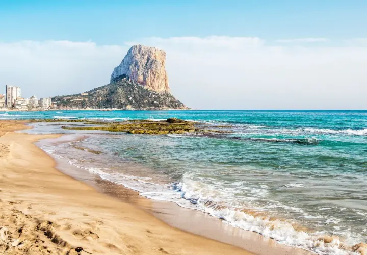 La playa de Calpe, con su arena dorada y el imponente Peñón de Ifach, invita a disfrutar del mar Mediterráneo.
