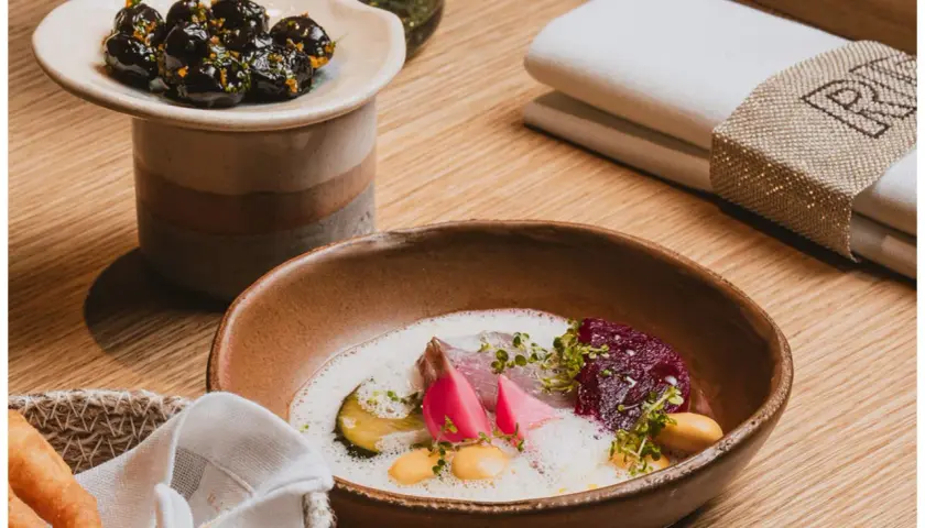 Plato de pescado con remolacha y espuma, aceitunas marinadas. ¡Una delicia para saber qué comer en Valencia!
