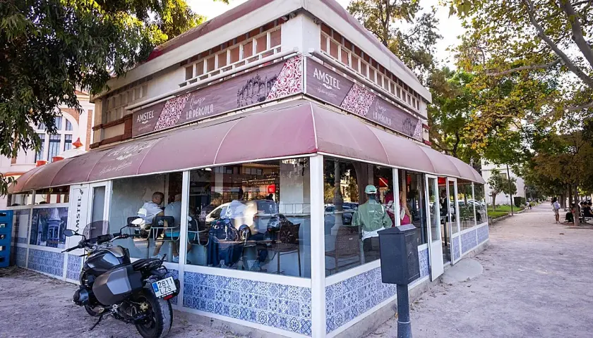 La pergola Valencia, un café con terraza y moto aparcada, invita a disfrutar del día.