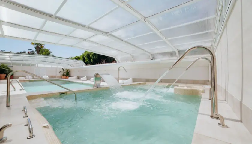 Piscinas termales cubiertas con chorros de agua y cascadas, perfectas para relajarse en el camping Alannia Guardamar.