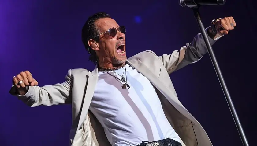 Marc Anthony canta con pasión en su concierto de Valencia, con los brazos extendidos y la boca abierta.