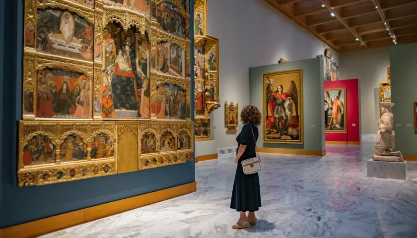 Una mujer admira un retablo gótico en uno de los museos de Valencia.