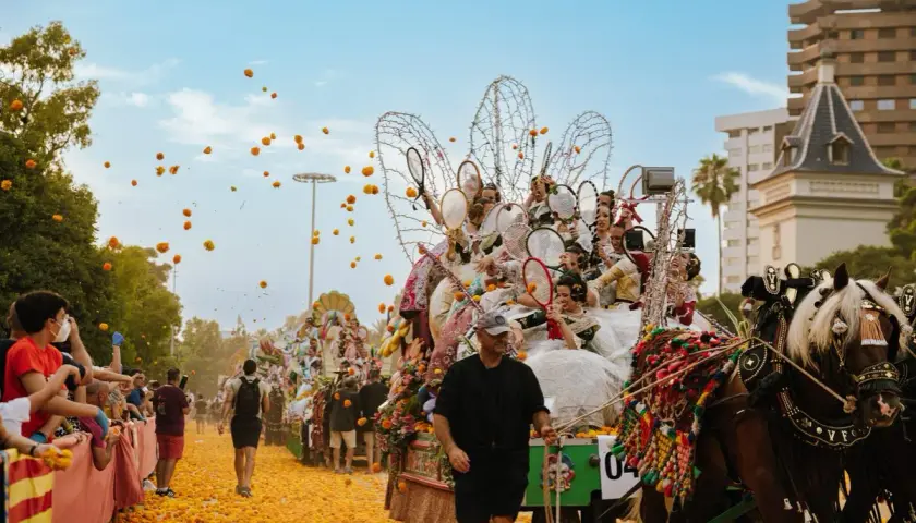 La batalla de las flores Valencia en pleno apogeo. Carrozas adornadas, gente lanzando flores y un ambiente festivo.