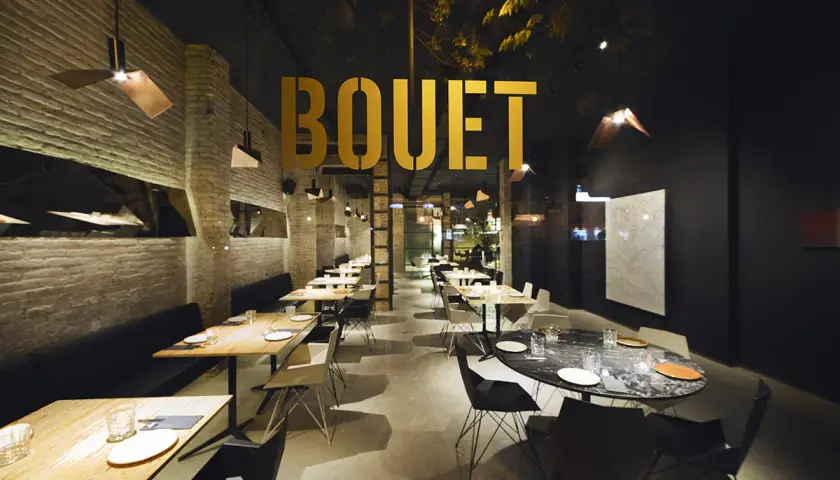 El interior moderno de **el bouet valencia**, con mesas listas para cenar y un ambiente elegante.