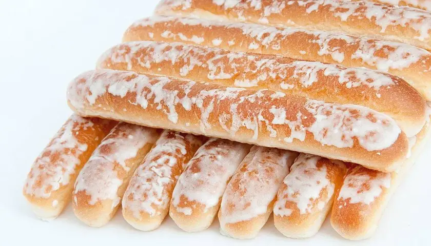 Dulces típicos de Valencia: barritas doradas cubiertas de glaseado blanco, apiladas en una pirámide.