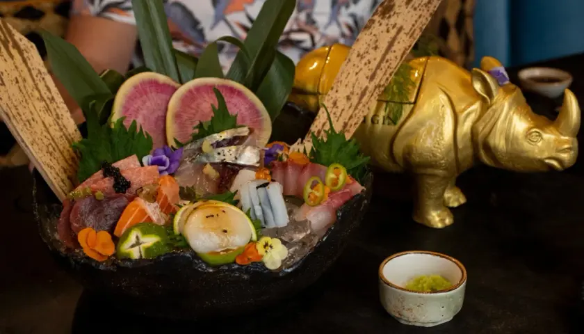 Un festín de sashimi en uno de los restaurantes temáticos de Valencia, con un rinoceronte dorado de decoración.