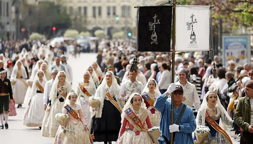 Procesión de mujeres con trajes tradicionales valencianos, celebrando cuando es San Vicente en Valencia.